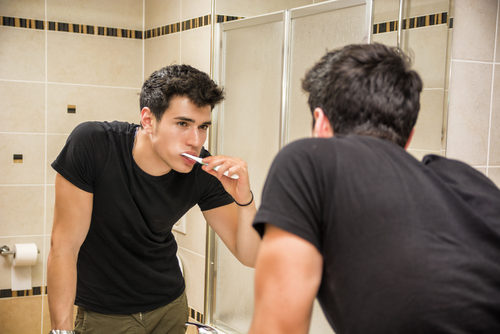 Mężczyzna myje zęby pastą chroniącą przed nadwrażliwością zębów