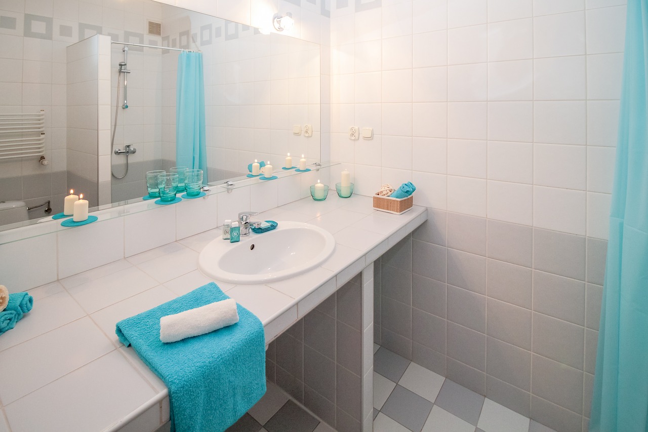 łazienka z lustrem i niebieskimi ręcznikami
