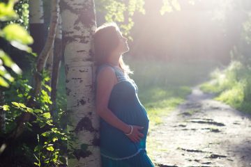 Kobieta w ciąży na tle drzew
